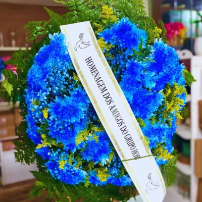 Coroa de Flores Blue cod 39 azul com faixa de homenagem, flores naturais e folhagens verdes para velório ou despedida