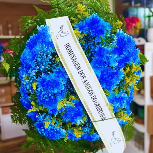Coroa de Flores Blue cod 39 azul com faixa de homenagem, flores naturais e folhagens verdes para velório ou despedida